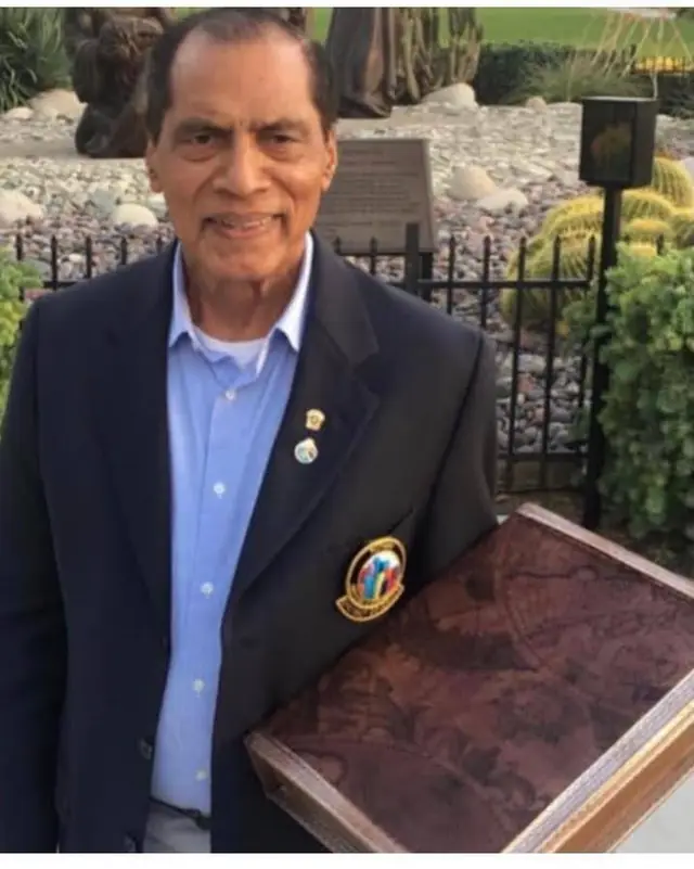 Dr. Manzoor R. Massey in a navy blazer, holding an antique map box